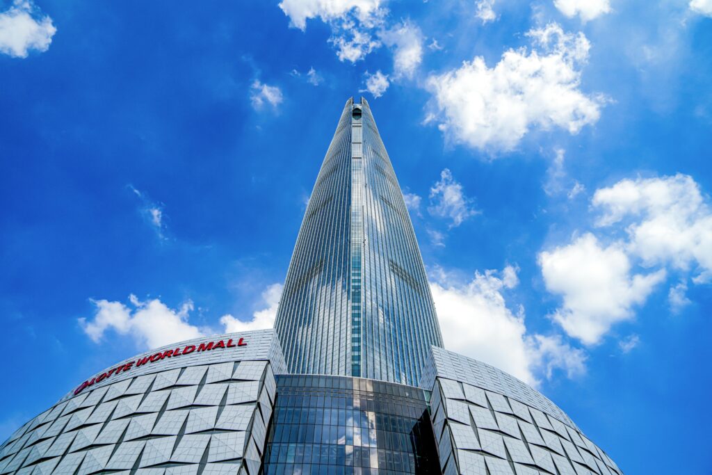 View of Lotte World Tower in Seoul under a bright blue sky, showcasing modern architecture.